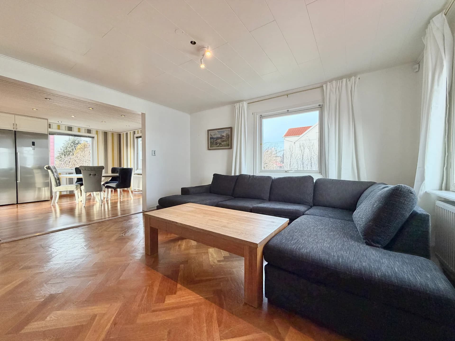 Bright living room with corner sofa, coffee table and parquet floor at Köpingsgatan 23